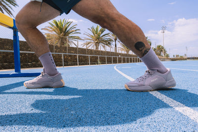 Atleta estirando con las zapatillas NOVA01 color taupe